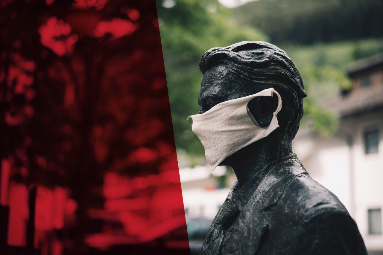 A public statue wears a cloth mask.